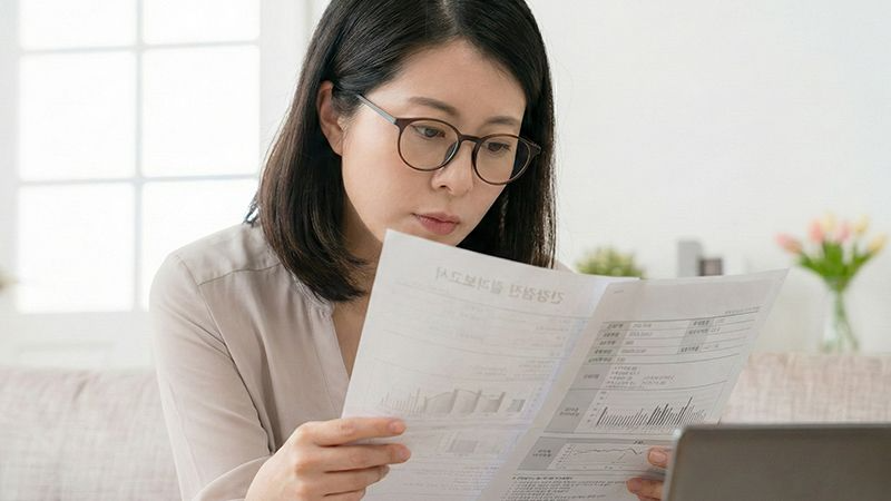  A patient carefully analyzing thyroid function test results from a health screening report.