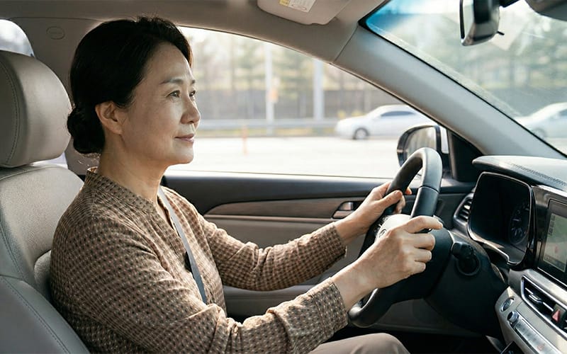 편안한 표정으로 운전을 하고 있는 고령 환자