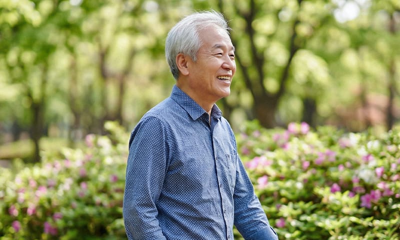 즐거운 표정으로 밖에서 산책을 즐기고 있는 노인