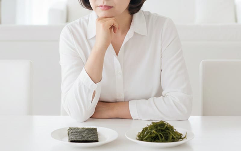 A patient looking confused and conflicted in front of a dining table set with seaweed.