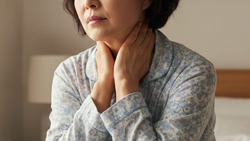 자고 일어난 환자, 자신의 목을 가볍게 감싸 쥐고 생각에 잠긴 모습.