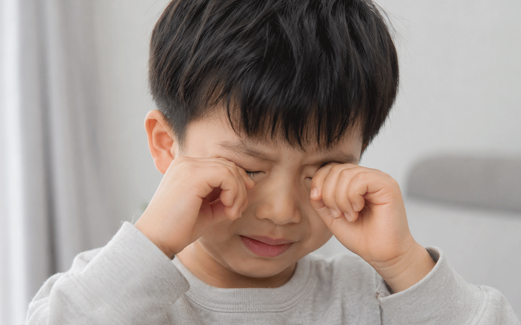 눈을 찡그리고 있는 어린 아이